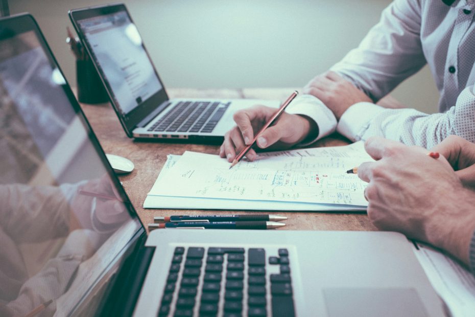 two men looking over a customer data spreadsheet